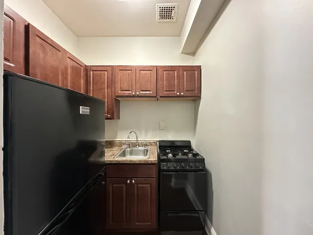a kitchen with a sink a stove and cabinets