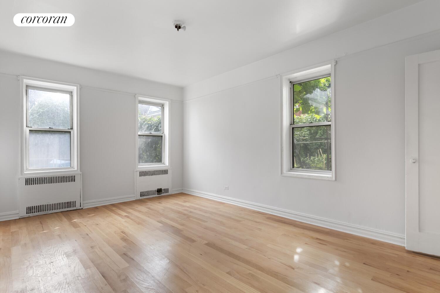 414 Albemarle Road, Unit 1D Brooklyn, NY 11218 - Photo 6 of 13 an empty room with wooden floor and windows