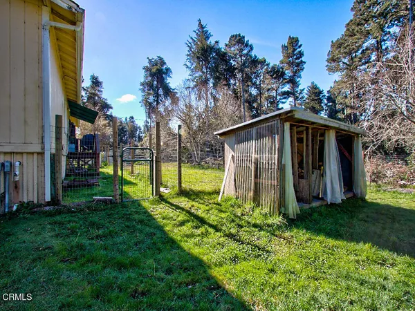 a view of a house with backyard and trees