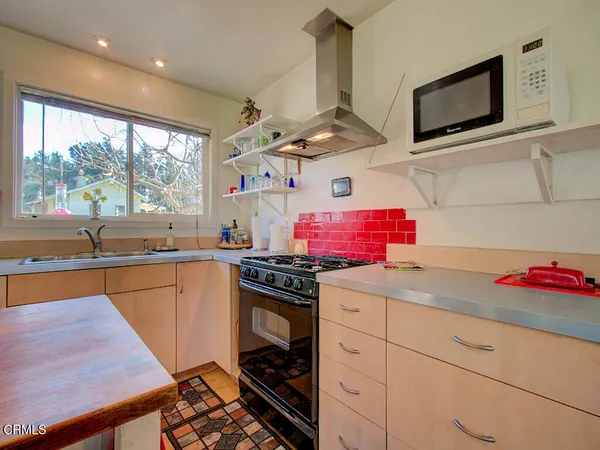 a kitchen with stainless steel appliances kitchen island granite countertop a stove a sink and a refrigerator
