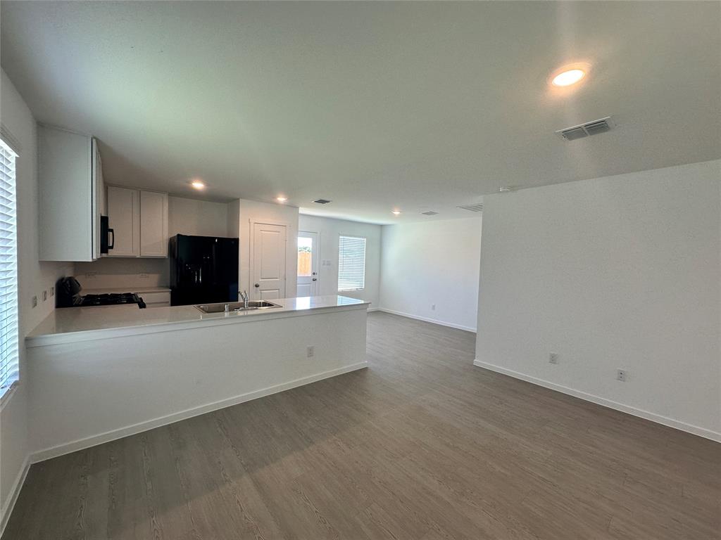 3800 Chambray Drive Sherman, TX 75092 - Photo 4 of 15 Kitchen with white cabinets, a peninsula, black appliances, recessed lighting, and dark wood-type flooring