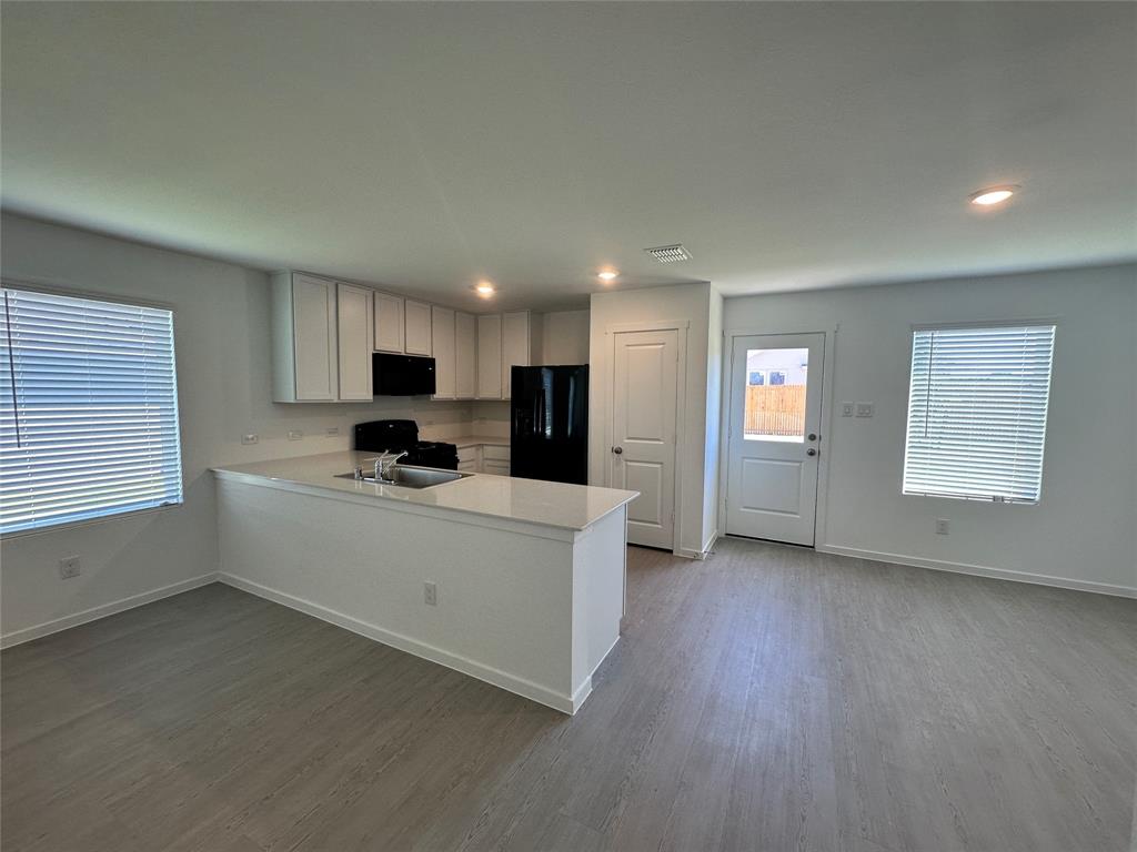 3800 Chambray Drive Sherman, TX 75092 - Photo 5 of 15 Kitchen featuring an office area, white cabinets, black appliances, a peninsula, and light wood finished floors