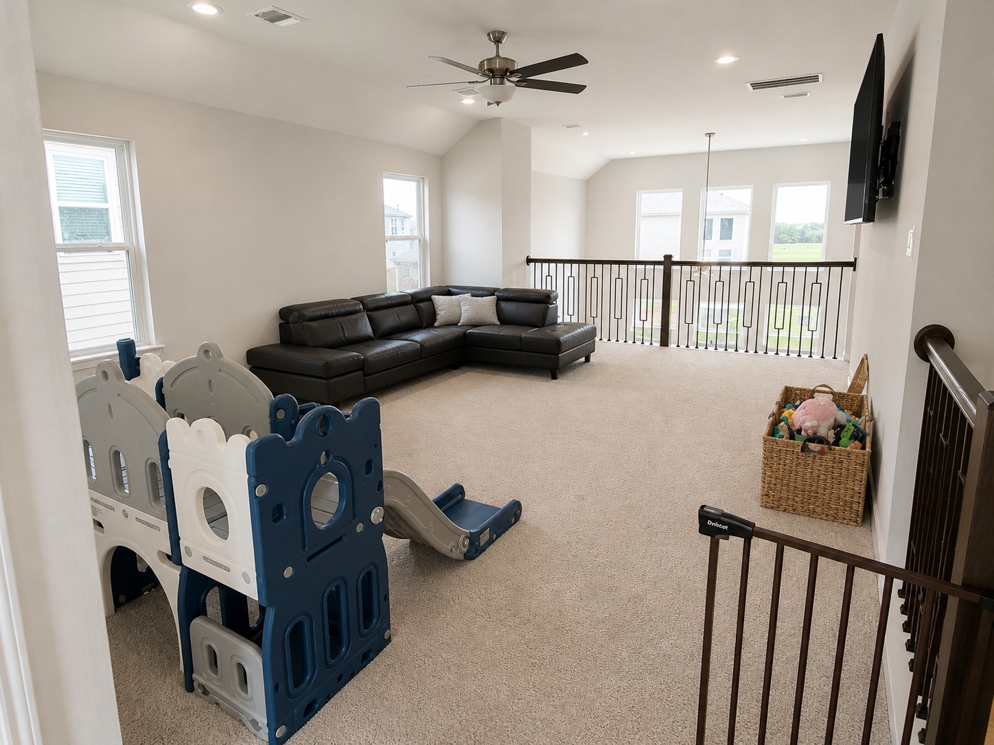 324 Windstar Road Liberty Hill, TX 78642 - Photo 4 of 6 Spacious loft area featuring vaulted ceilings, recessed lighting, ceiling fan, carpeted flooring, and a wrought iron railing system