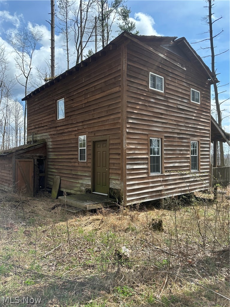 44800 Jim Stimpert Road Lewisville, OH 43754 - Photo 2 of 49 Side / Back of Rustic Cabin Door to the left holds water tank and Electric box