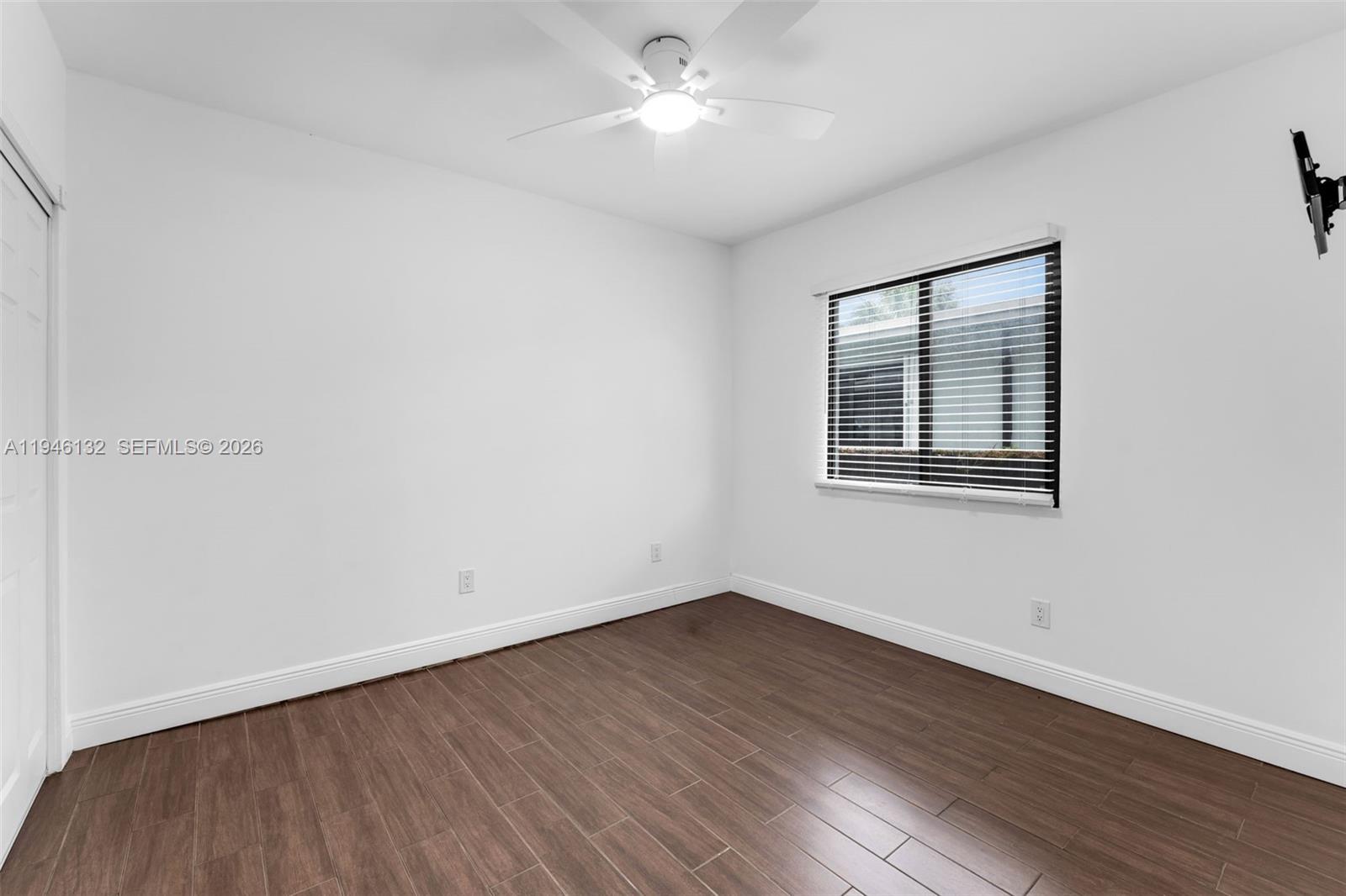 5790 Southwest 5th Street, Unit FRONT Miami, FL 33144 - Photo 11 of 12 a view of empty room with wooden floor and fan