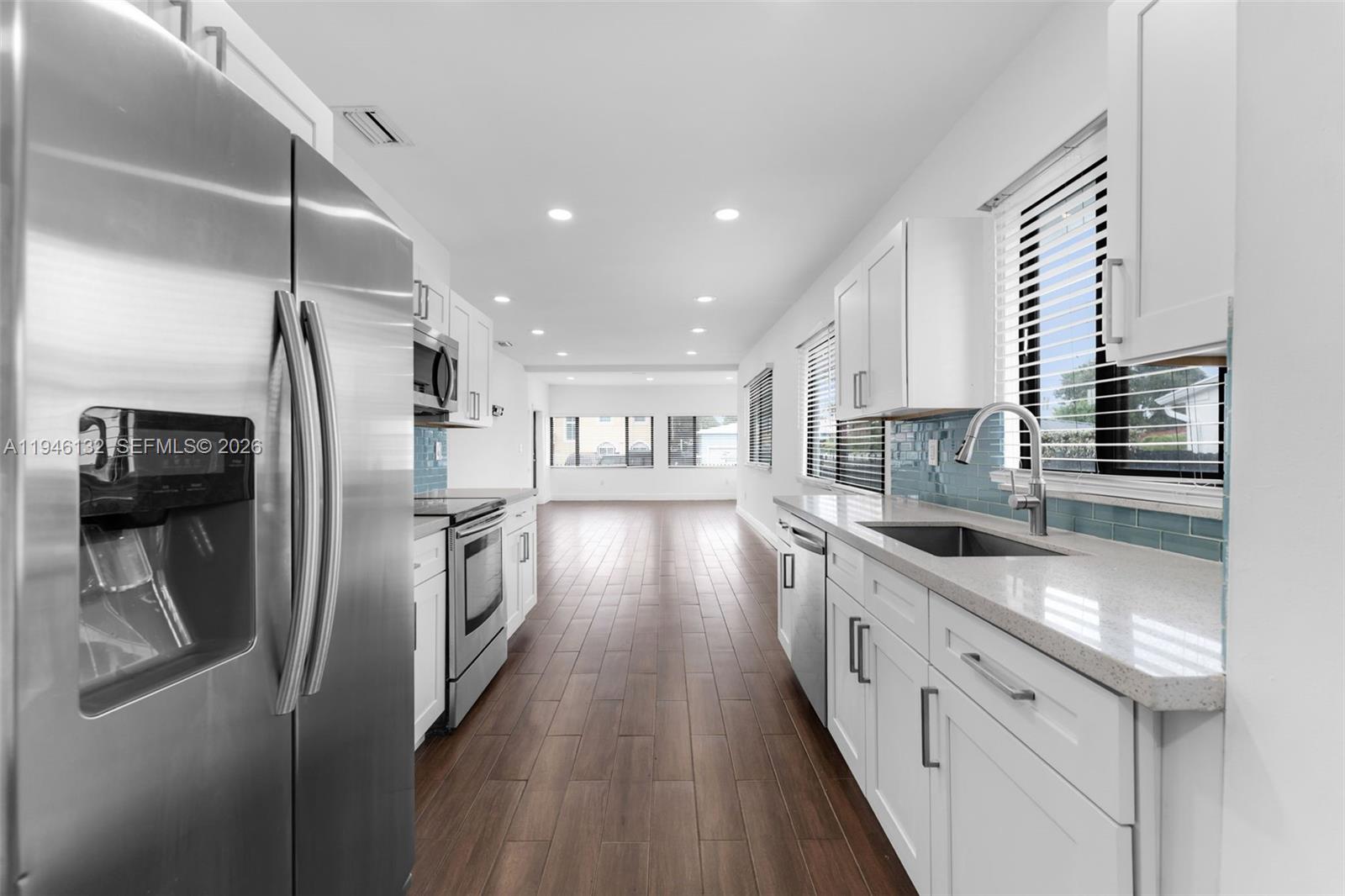 5790 Southwest 5th Street, Unit FRONT Miami, FL 33144 - Photo 8 of 12 a kitchen with stainless steel appliances granite countertop a refrigerator a sink and a stove