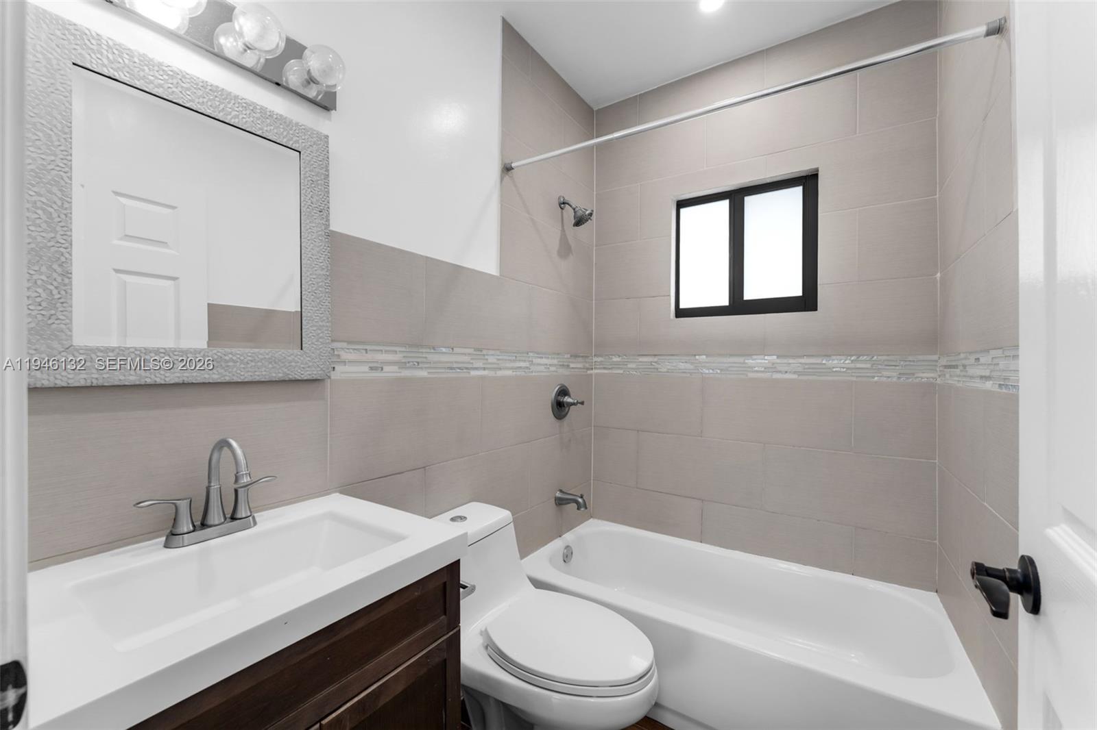 5790 Southwest 5th Street, Unit FRONT Miami, FL 33144 - Photo 9 of 12 a bathroom with a sink toilet vanity and tub