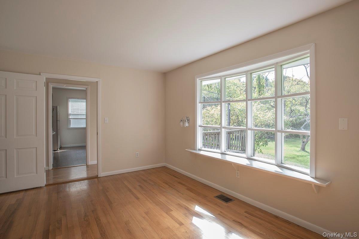 401 West Dover Road Pawling, NY 12564 - Photo 6 of 24 Hardwood flooring, painted interior walls, bay window with sill, white interior doors, and a partial outdoor landscape