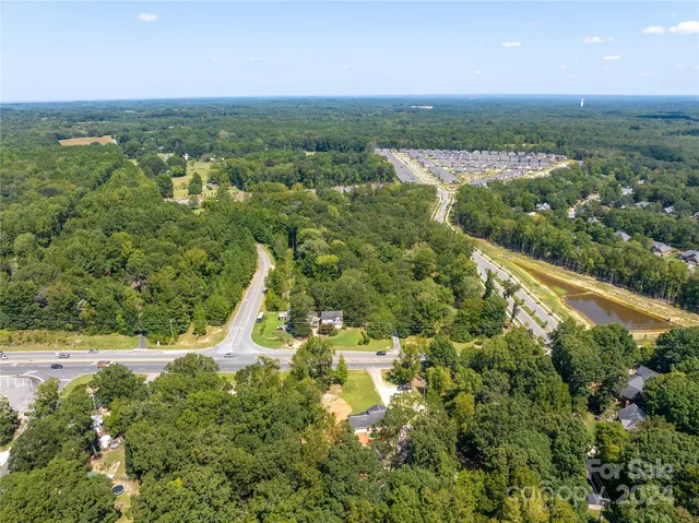 an aerial view of residential houses with outdoor space and trees