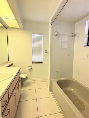 a bathroom with a granite countertop sink a toilet and shower