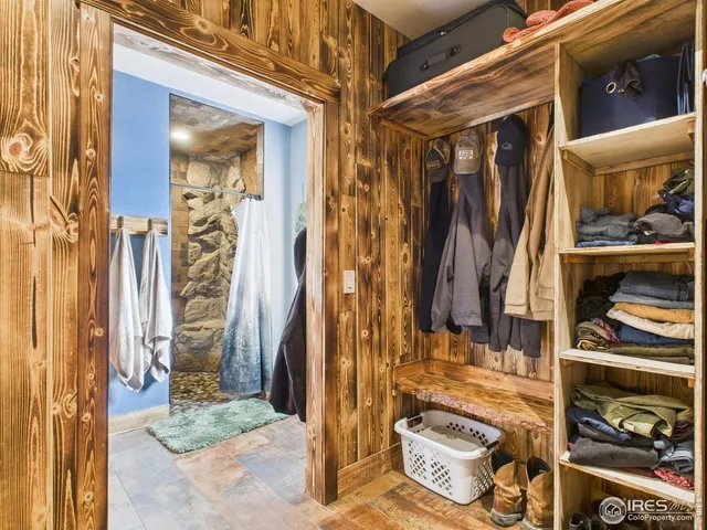 a view of walk in closet with clothes and shoes