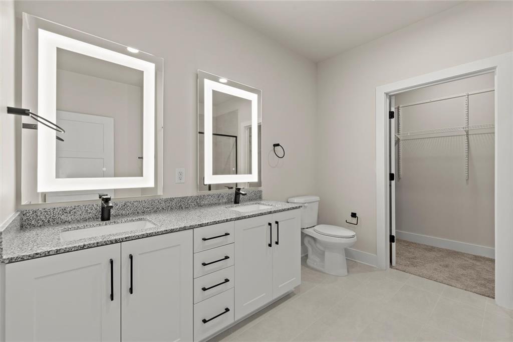 2648 Sandy Plains Road, Unit 422 Marietta, GA 30066 - Photo 20 of 37 a bathroom with a granite countertop toilet sink and mirror