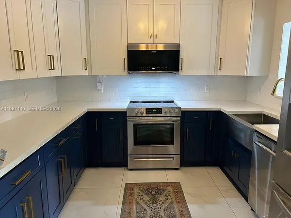 a kitchen with stainless steel appliances granite countertop white cabinets and a stove