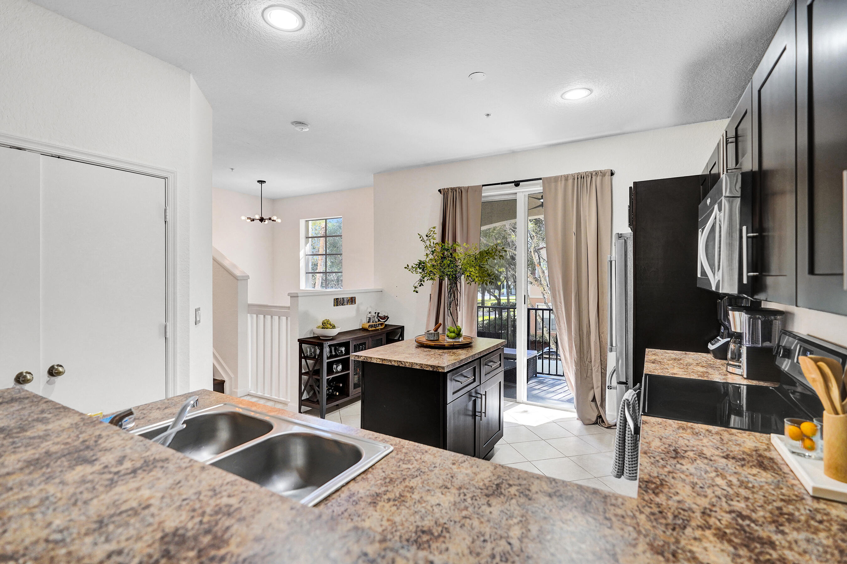 4533 Danson Way Delray Beach, FL 33445 - Photo 10 of 92 a kitchen with stainless steel appliances granite countertop a sink stove and refrigerator