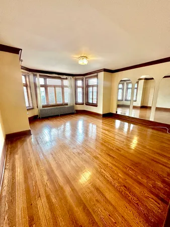 a view of empty room with wooden floor