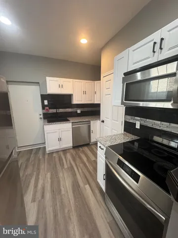 a kitchen with granite countertop a stove and a sink