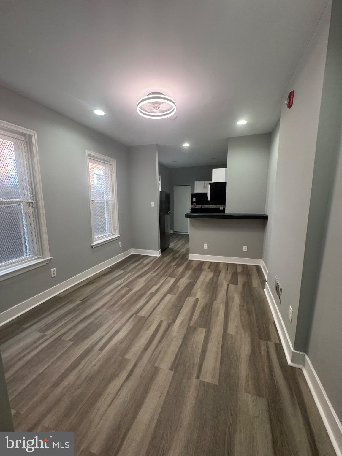 1717 North 26th Street, Unit 1 Philadelphia, PA 19121 - Photo 5 of 11 an empty room with wooden floor and a kitchen view