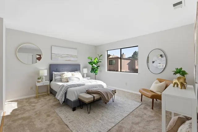 a bedroom with a bed a clock on the wall and dresser