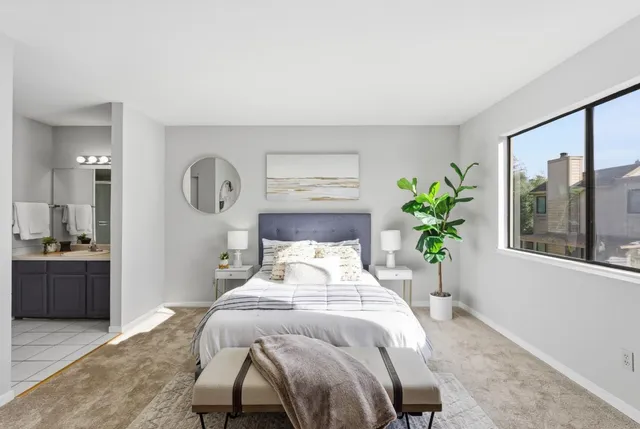 a bedroom with a bed and a potted plant