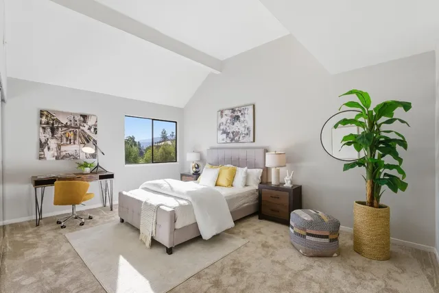 a bedroom with a bed table flowerpot and window
