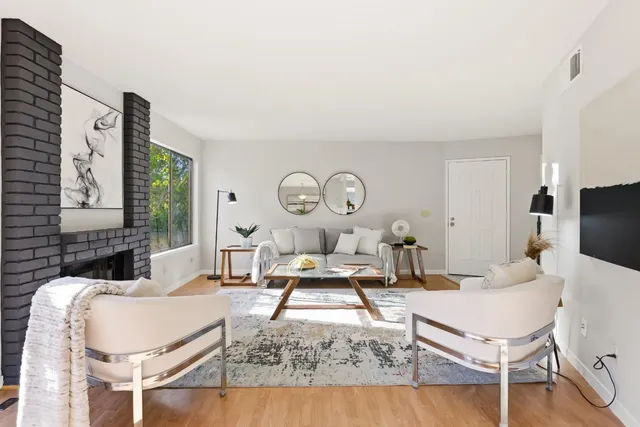 a living room with furniture a clock and a large window