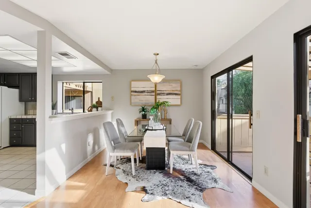 a dining room with wooden floor a glass table and chairs