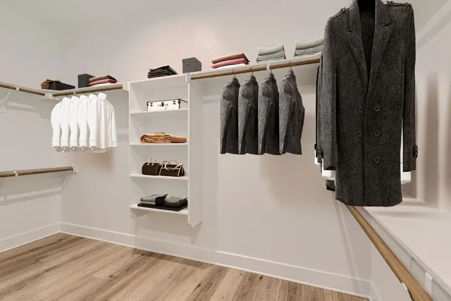 a view of walk in closet with clothes and shoes
