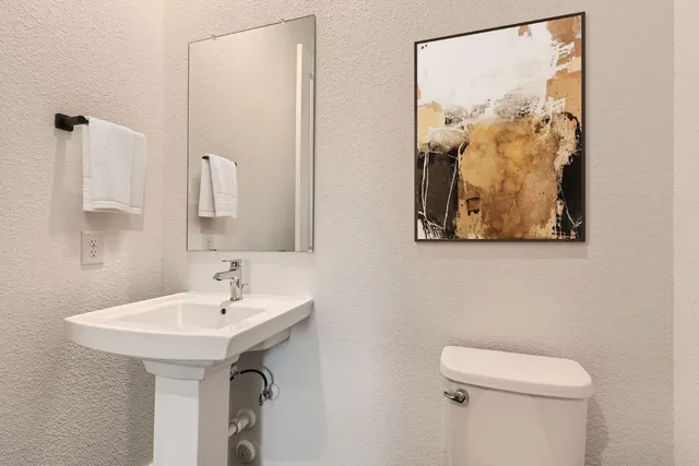 a bathroom with a toilet sink and mirror