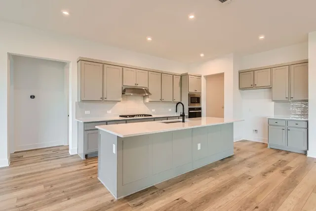 a kitchen with stainless steel appliances a stove a sink and a refrigerator