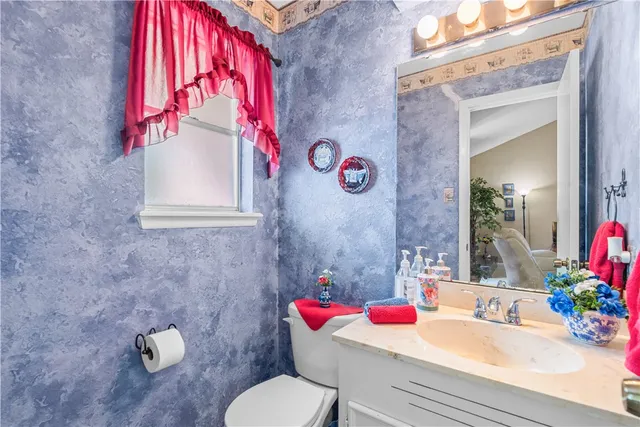 a bathroom with a sink mirror vanity and toilet