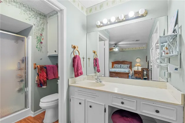 a bathroom with a sink vanity mirror and toilet