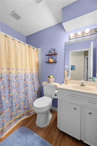 a spacious bathroom with a granite countertop toilet a sink and a large mirror