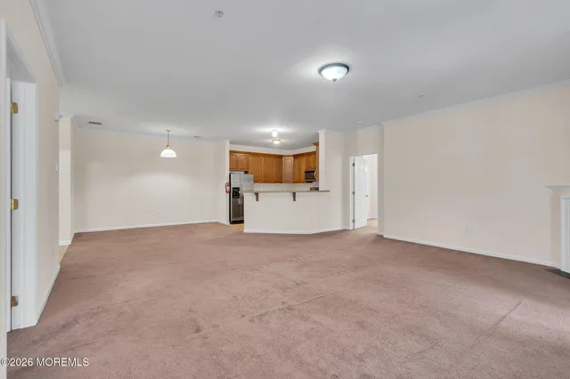a view of a big room with a refrigerator and white walls