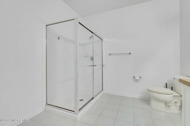 a bathroom with a granite countertop toilet and a shower