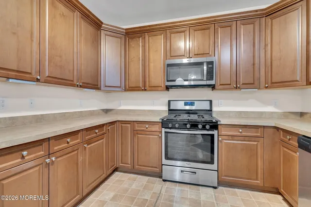 a kitchen with granite countertop wood cabinets and stainless steel appliances