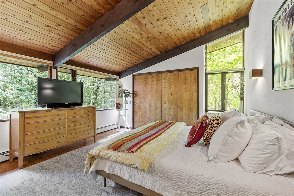 157 Carleton Road Carlisle, MA 01741 - Photo 21 of 42 a bedroom with a large bed and a flat tv screen on dresser
