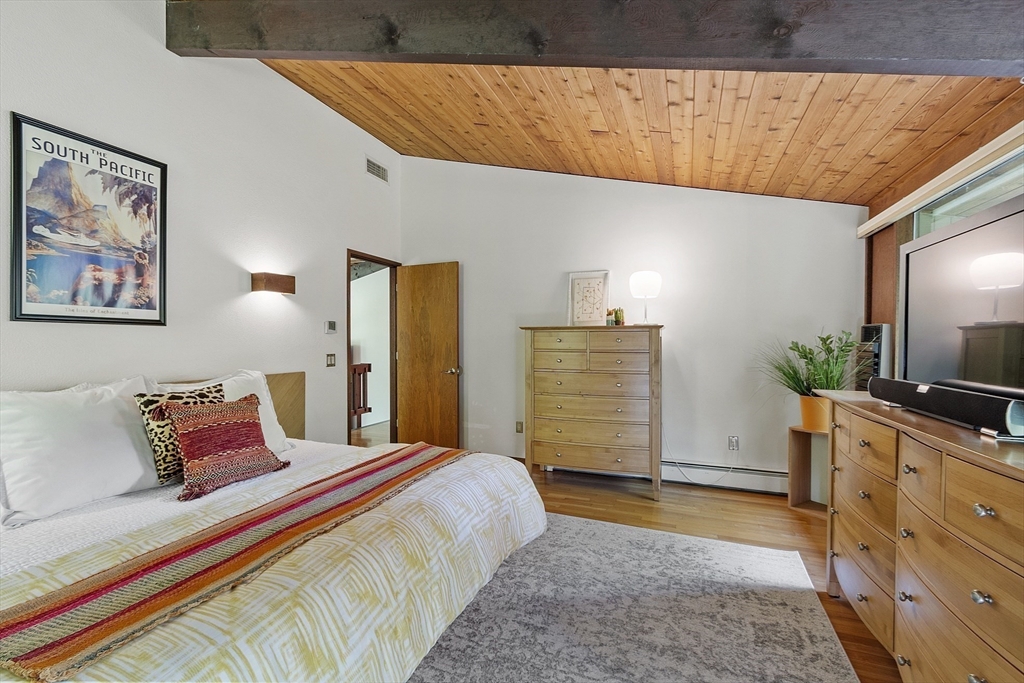 157 Carleton Road Carlisle, MA 01741 - Photo 22 of 42 a spacious bedroom with a bed and a flat screen tv