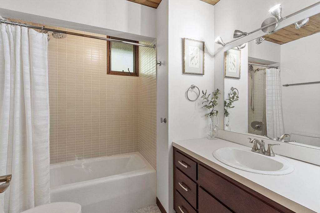 157 Carleton Road Carlisle, MA 01741 - Photo 31 of 42 a bathroom with a granite countertop sink a mirror a shower and a bathtub