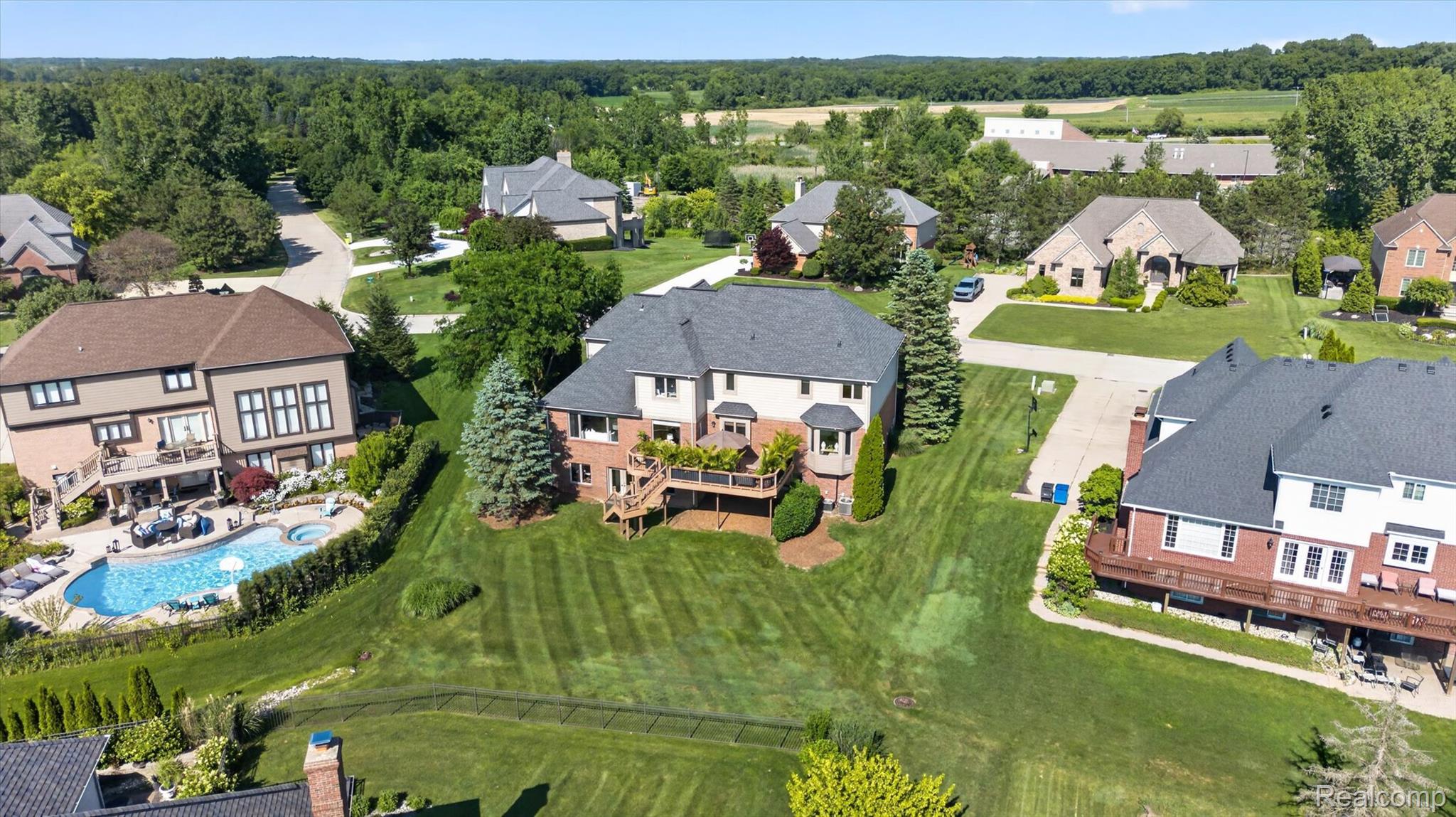 3804 Elk Drive Rochester, MI 48306 - Photo 65 of 75 Expansive backyard featuring a large swimming pool with integrated spa and surrounding patio space