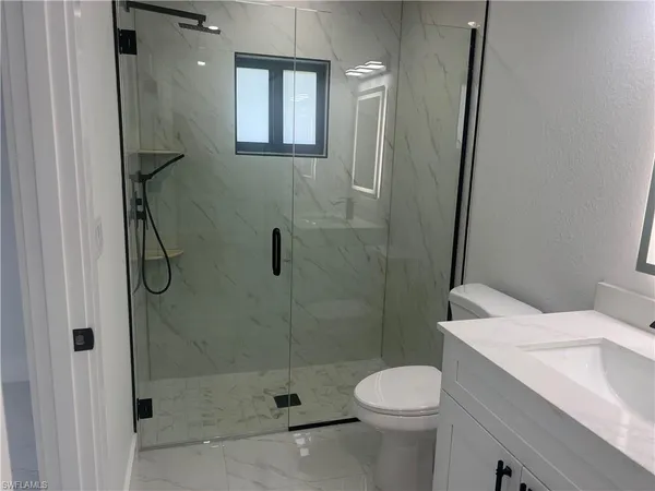a bathroom with a sink toilet and shower