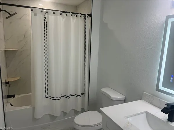 a white toilet sitting next to a bath tub shower