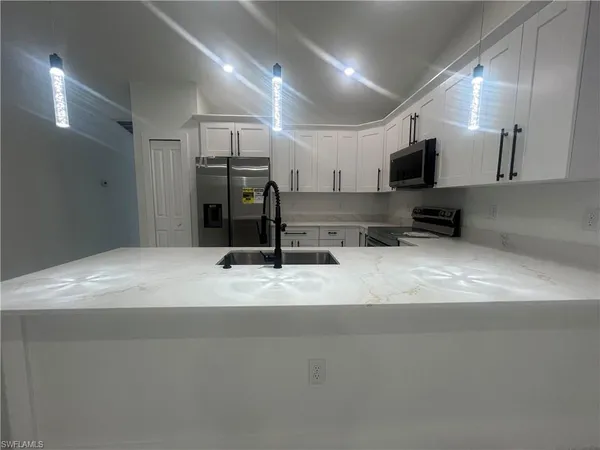 a kitchen with stainless steel appliances granite countertop a refrigerator and a sink