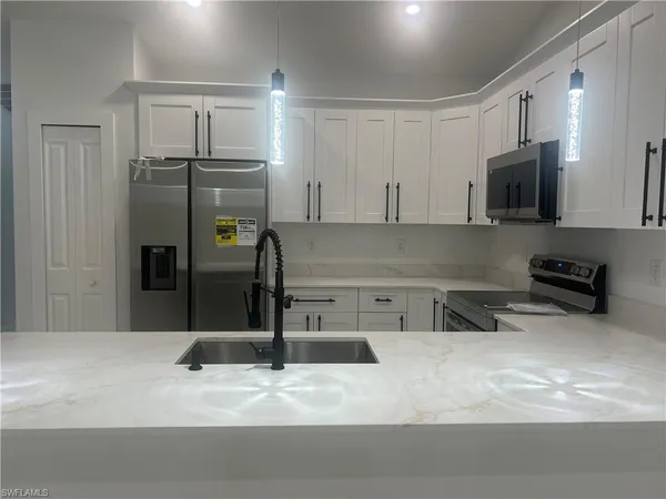 a kitchen with stainless steel appliances granite countertop a sink and refrigerator