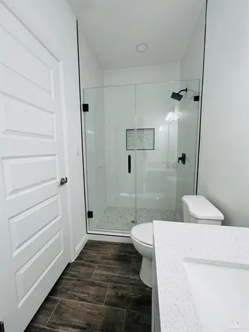 a bathroom with a sink a toilet and shower
