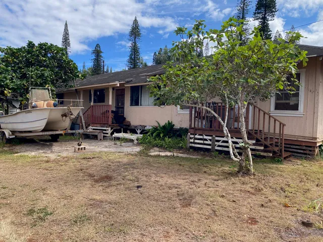 a view of a house with backyard and sitting area