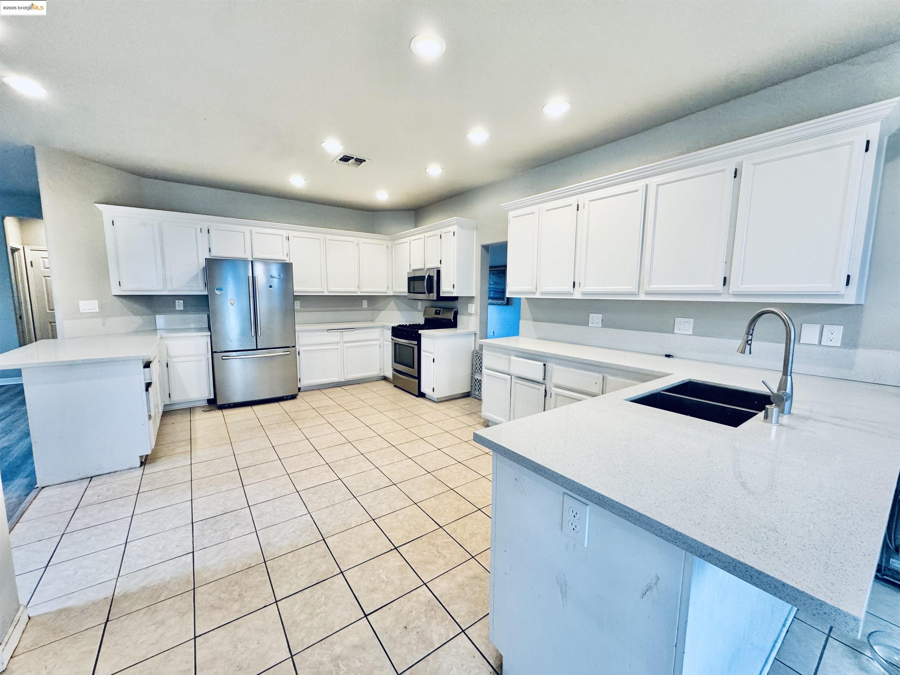 756 Rubier Way Rio Vista, CA 94571 - Photo 6 of 20 a kitchen with a sink a stove a refrigerator and white cabinets