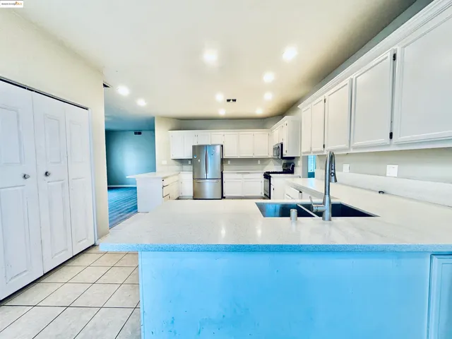 an empty room with wooden floor a ceiling fan a fireplace and a window