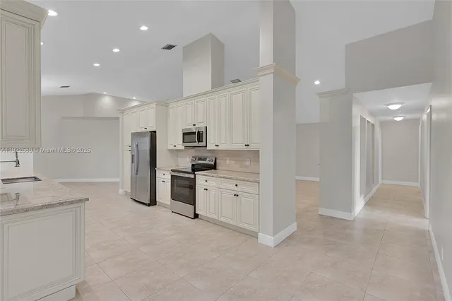 a kitchen with white cabinets and stainless steel appliances