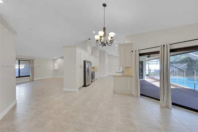 a view of a big room with chandelier and windows