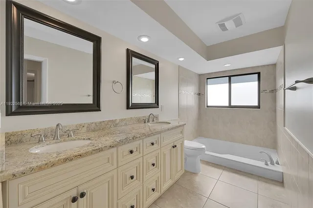 a bathroom with a granite countertop sink mirror and bathtub